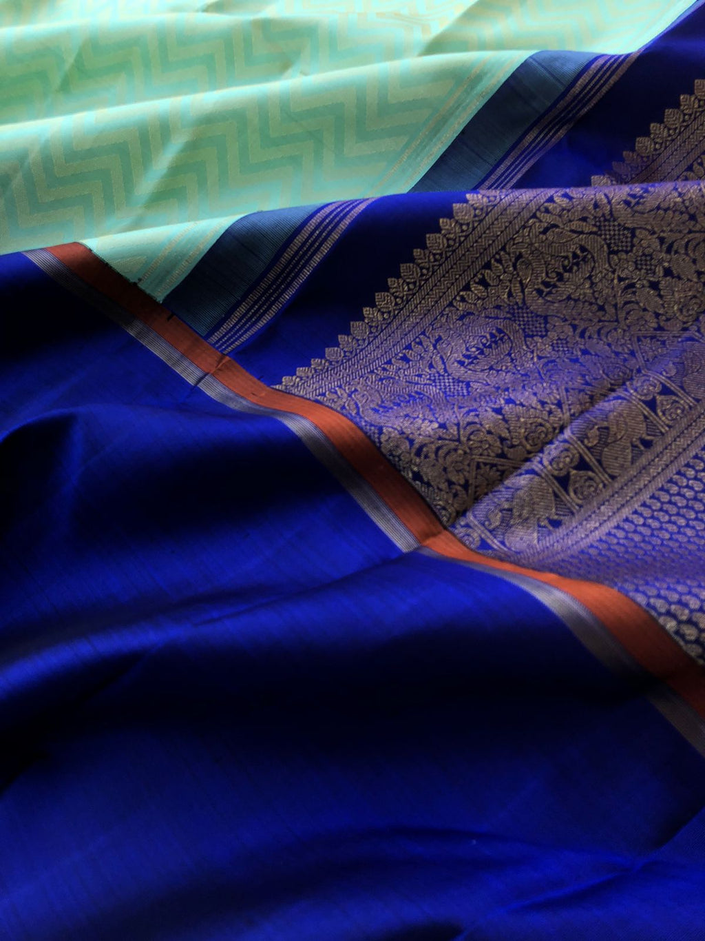 Leela - Legacy Of Kanchivarams - gorgeous chevron V pattern weave woven body in pastel pale pista green body with dark ink blue woven broad borders