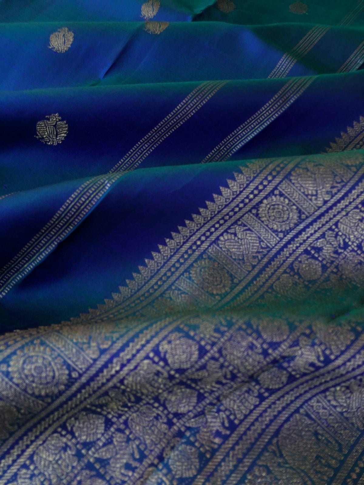 Tara - Traditional Colours on Traditional Kanchivarams - the best of dual to mayil kaluthu ( peacock neck tone blue green ) with solid gold zari woven pallu and borders