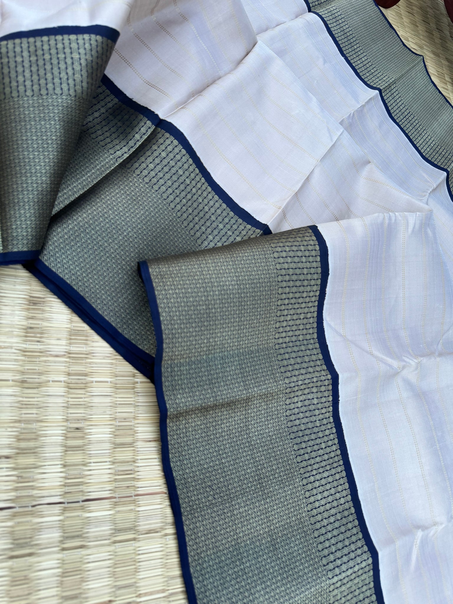 Pastel Kanchivarams - a chalk white absolutely no zari Korvai Kanchivaram with navy blue pallu and blouse