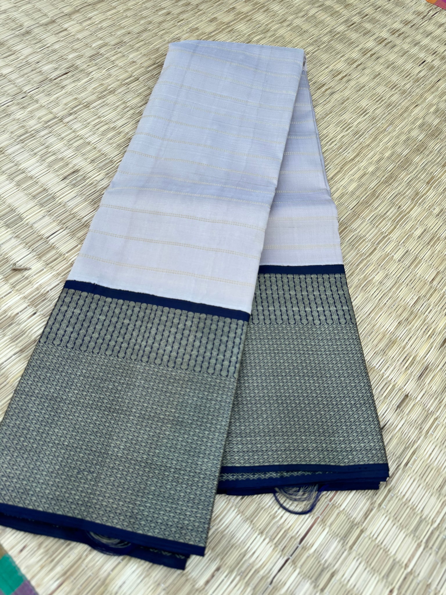 Pastel Kanchivarams - a chalk white absolutely no zari Korvai Kanchivaram with navy blue pallu and blouse