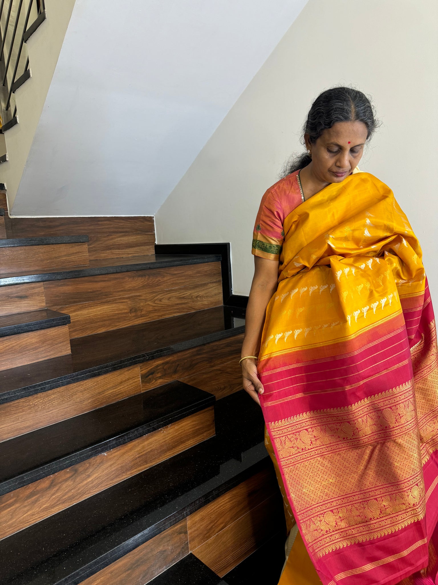 Kanchivaram Concepts - a amazing raising parrots of silver and gold zari woven buttas in a golden mustard body with red pallu and blouse