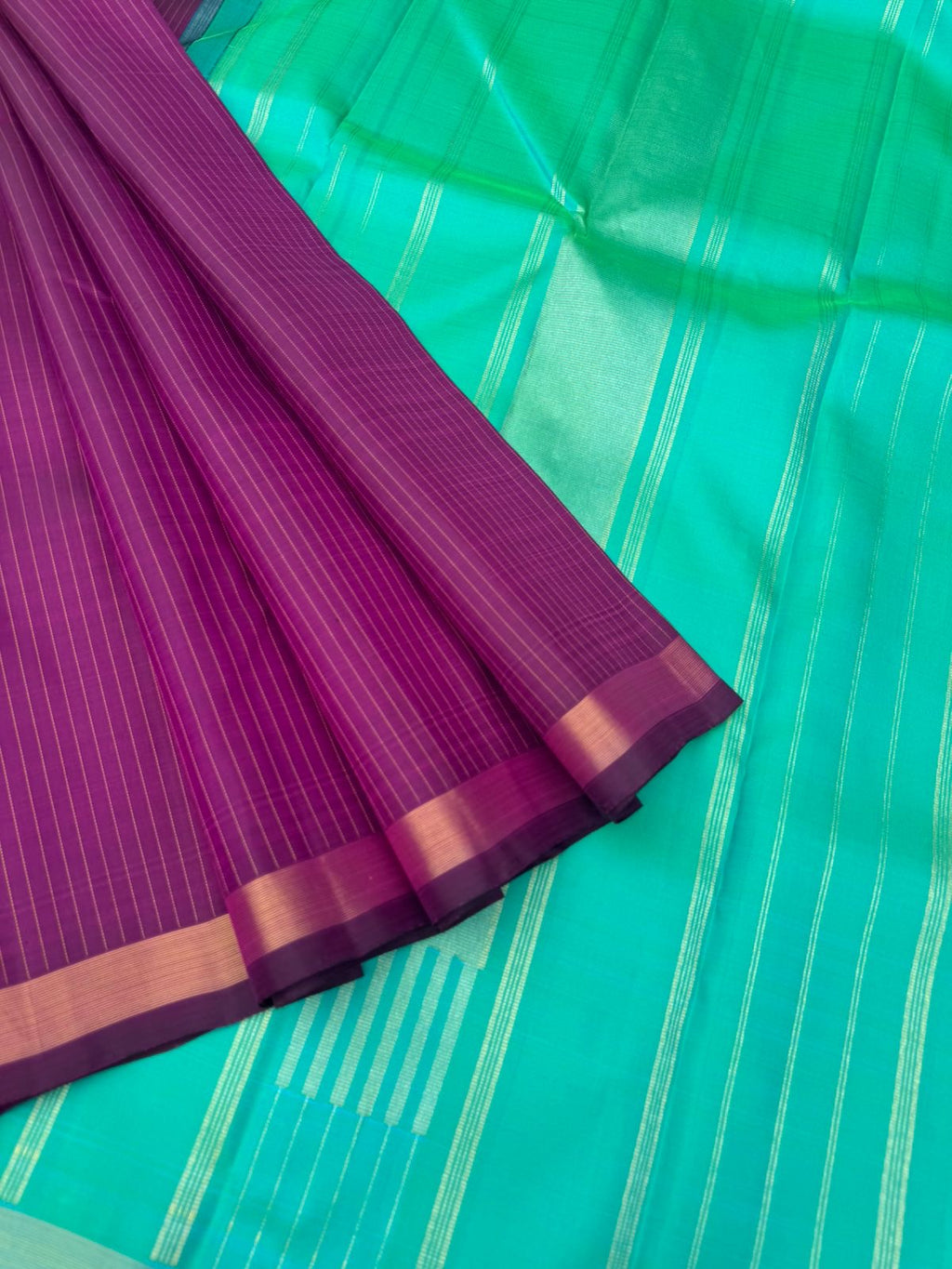 Shree - Simple and Elegant Kanchivarams - a stunning deep purple vertical muthu strips body with a dual tone turquoise blue pallu and blouse