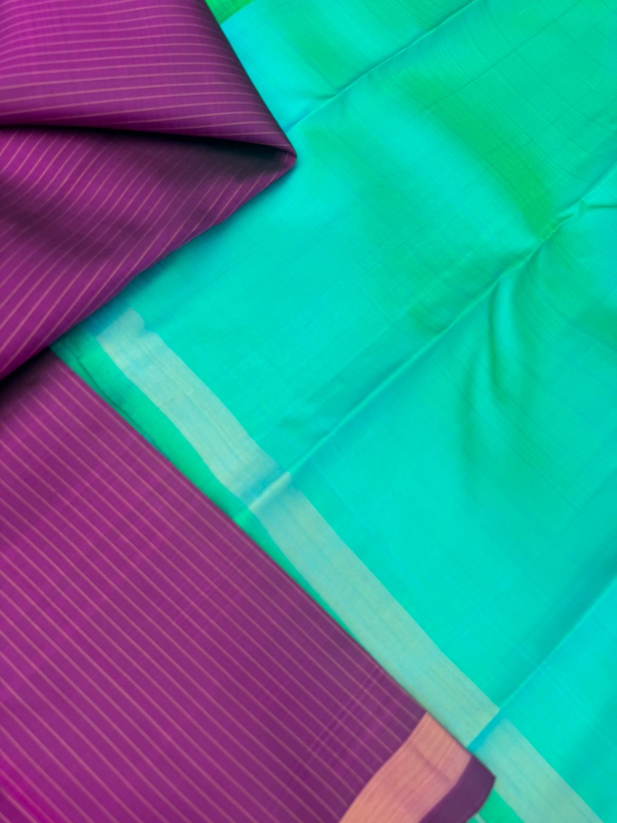 Shree - Simple and Elegant Kanchivarams - a stunning deep purple vertical muthu strips body with a dual tone turquoise blue pallu and blouse