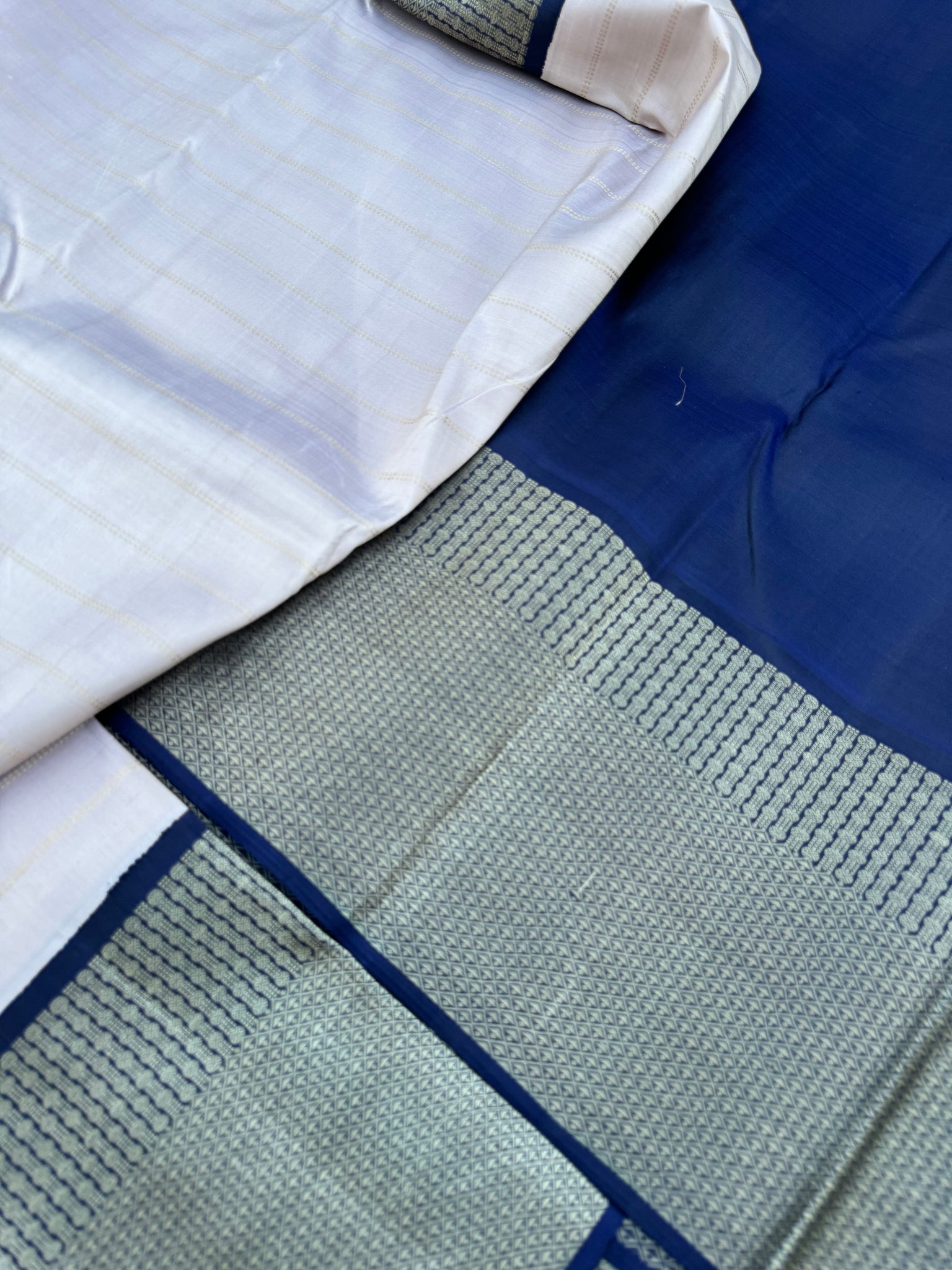 Pastel Kanchivarams - a chalk white absolutely no zari Korvai Kanchivaram with navy blue pallu and blouse