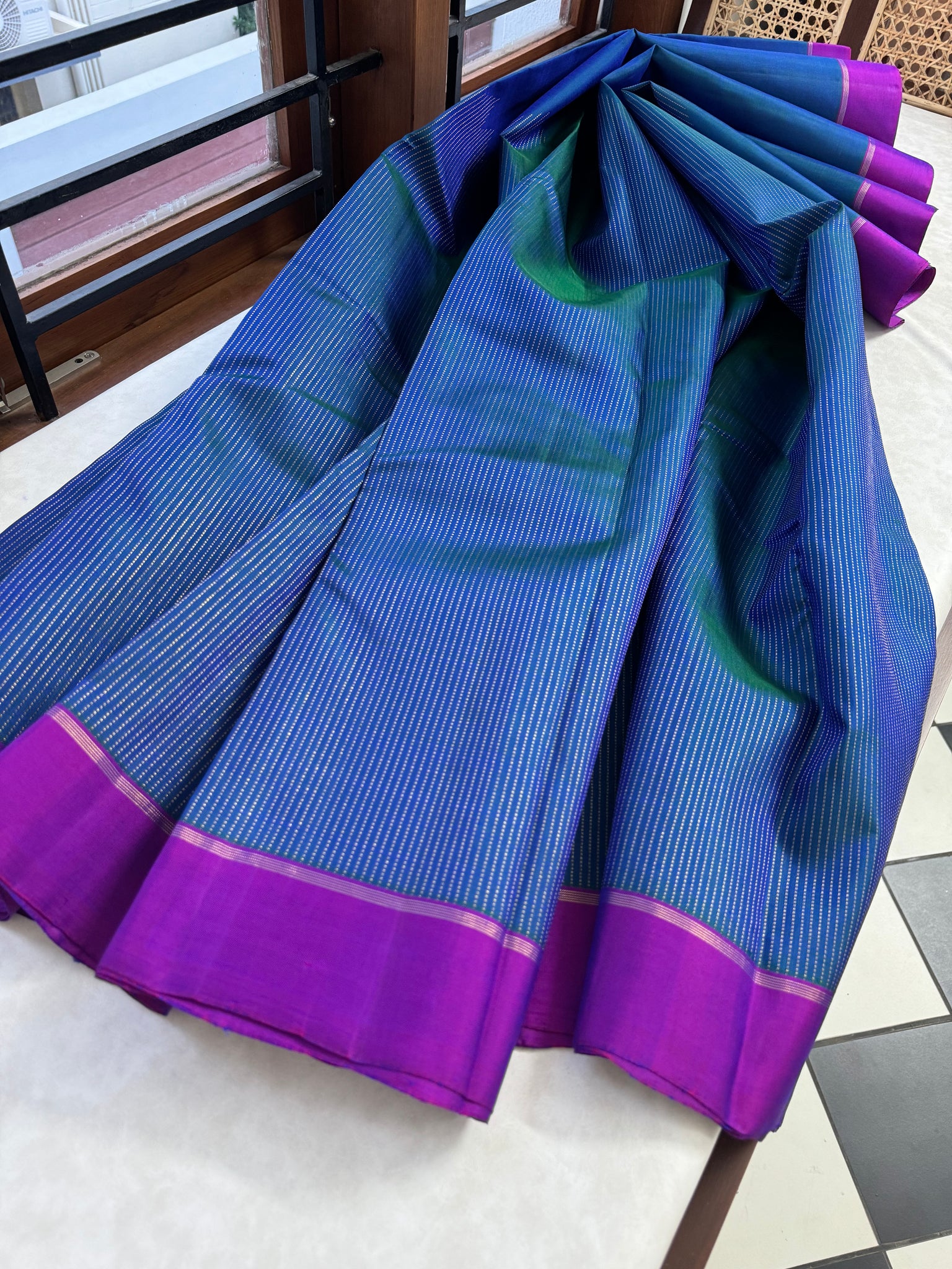 Adhyayam – The No Motifs Kanchivaram - the beautiful raising oosi vaanam in stunning dual tone peacock blue green body and majentha borders pallu and blouse