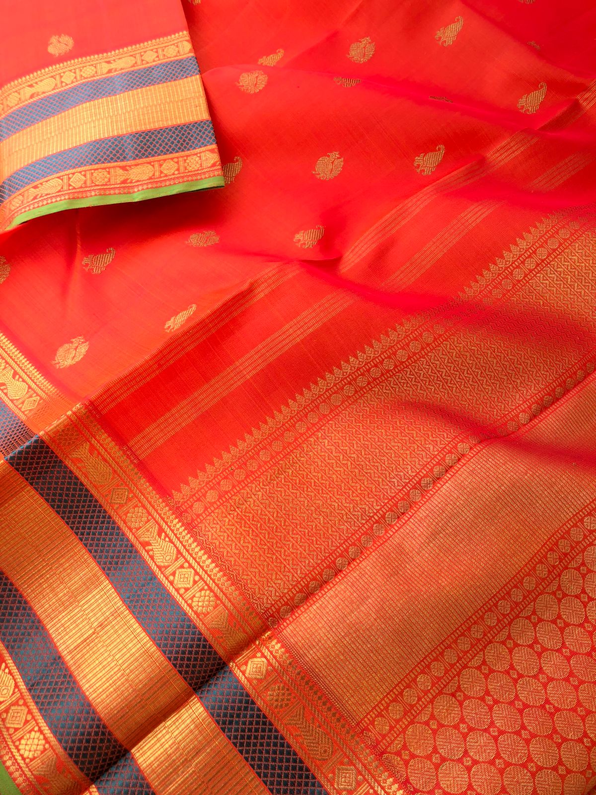 The Golden Treasures Of Kanchivaram - the best red short orange with paisley and pakshi golden buttas over the body with fish pett woven beautiful borders